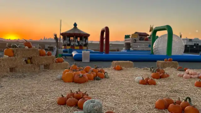 A wide sunset view across the pumpkin patch attractions